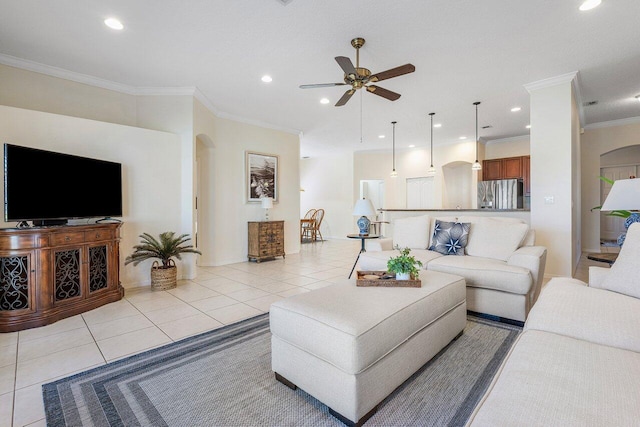 living area with arched walkways, light tile patterned flooring, ornamental molding, ceiling fan, and recessed lighting