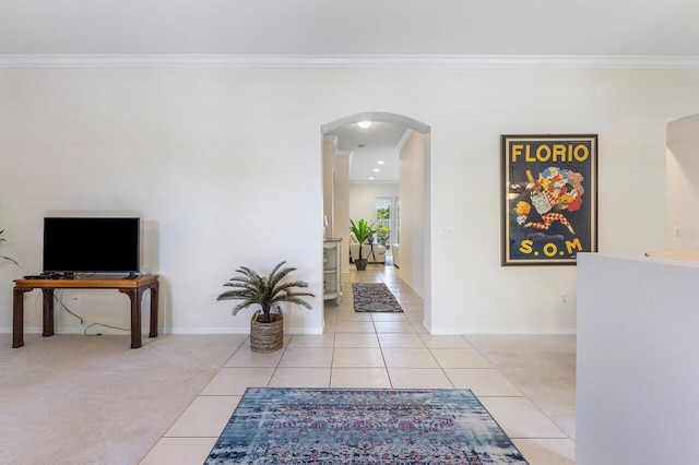 hall featuring arched walkways, light tile patterned floors, ornamental molding, and baseboards
