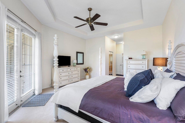 carpeted bedroom with access to outside, a tray ceiling, ceiling fan, and connected bathroom