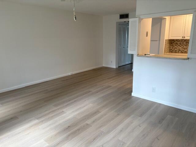 unfurnished room with light wood-style flooring and baseboards