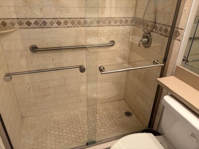 full bathroom featuring toilet and a shower stall