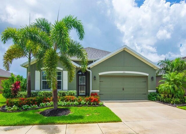 2172 Harwick Cir SW, Vero Beach, FL 32968 - view of front of property featuring an attached garage, concrete driveway, a front yard, and stucco siding