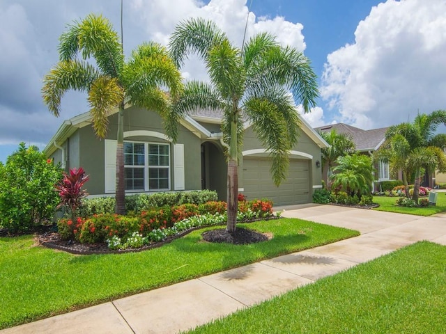 2172 Harwick Cir SW, Vero Beach, FL 32968 - view of front of house with a garage, concrete driveway, a front yard, and stucco siding