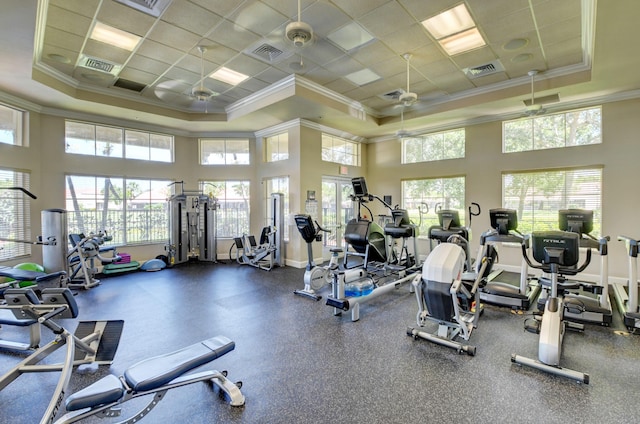 gym featuring crown molding, ceiling fan, a high ceiling, and baseboards