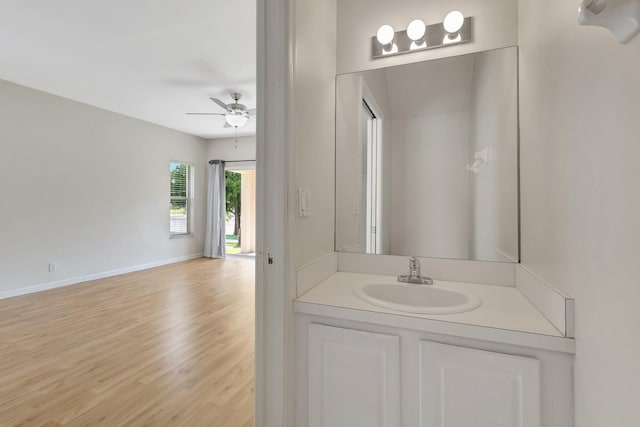 bathroom featuring wood finished floors, a ceiling fan, baseboards, and vanity