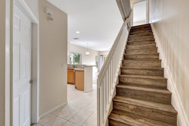 staircase with tile patterned flooring, baseboards, and recessed lighting