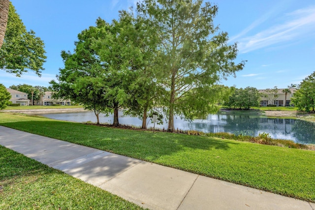 view of community with a water view and a yard