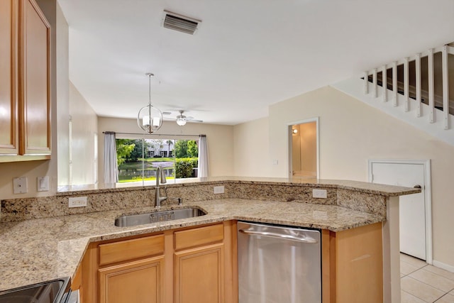 kitchen with stainless steel dishwasher, a sink, light tile patterned floors, and light stone countertops