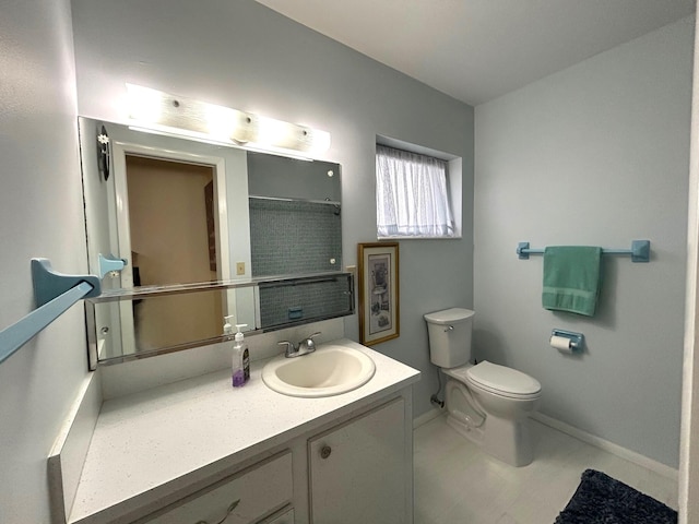 bathroom featuring baseboards, toilet, and vanity