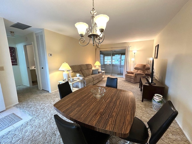 dining room with light colored carpet and a chandelier