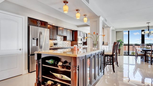 4740 S Ocean Blvd Unit 710, Highland Beach, FL 33487 - kitchen featuring stainless steel fridge with ice dispenser, backsplash, light stone counters, dark brown cabinetry, and expansive windows