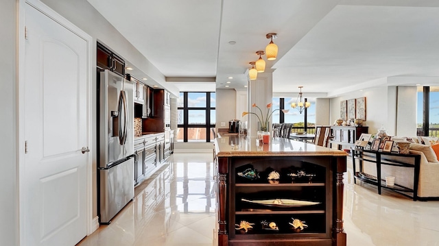 4740 S Ocean Blvd Unit 710, Highland Beach, FL 33487 - kitchen with stainless steel fridge, a chandelier, dark brown cabinetry, open floor plan, and pendant lighting
