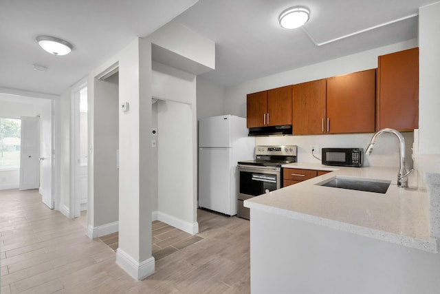 1011 Green Pine Blvd Unit G1, West Palm Beach, FL 33409 - kitchen featuring electric stove, freestanding refrigerator, under cabinet range hood, black microwave, and a sink