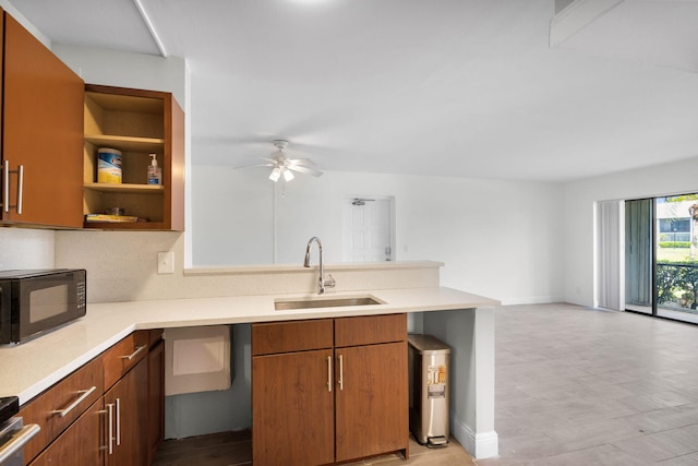 1011 Green Pine Blvd Unit G1, West Palm Beach, FL 33409 - kitchen with black microwave, a sink, a ceiling fan, a peninsula, and light countertops