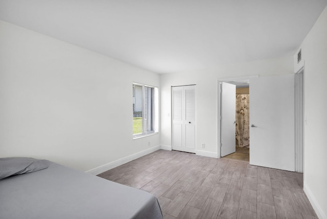 1011 Green Pine Blvd Unit G1, West Palm Beach, FL 33409 - unfurnished bedroom featuring wood finished floors, baseboards, and a closet
