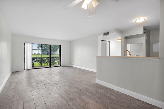 1011 Green Pine Blvd Unit G1, West Palm Beach, FL 33409 - unfurnished living room featuring baseboards, a ceiling fan, wood finished floors, and a sink