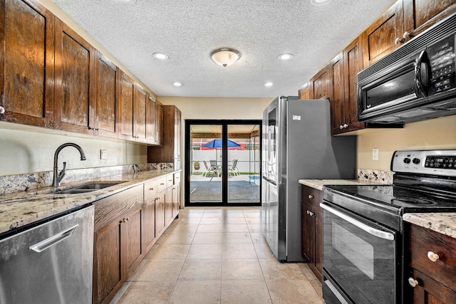 21212 Escondido Way, Boca Raton, FL 33433 - kitchen with stainless steel appliances, a sink, light stone counters, a textured ceiling, and light tile patterned flooring