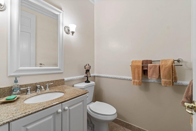 bathroom featuring toilet, vanity, and baseboards