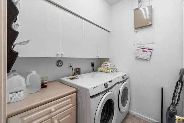 clothes washing area featuring cabinet space, washer and dryer, light tile patterned floors, and baseboards