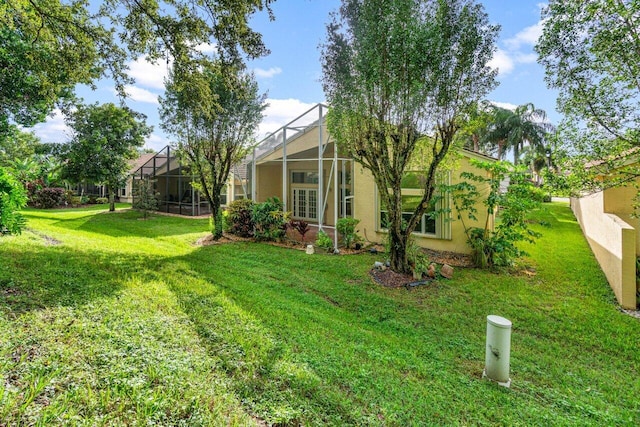 view of grassy yard with a lanai