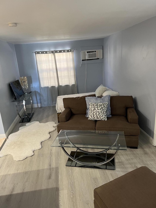1081 SE Monterey Rd Unit 3-17, Stuart, FL 34994 - living area featuring wood finished floors, a wall mounted air conditioner, and baseboards