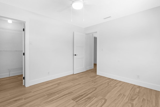 4060 Lake Dr, Coconut Creek, FL 33066 - unfurnished bedroom with light wood-type flooring, a spacious closet, a closet, and baseboards