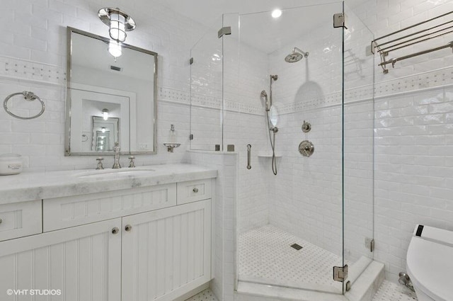 3421 S Ocean Blvd Unit 1, Highland Beach, FL 33487 - full bathroom with tile walls, a stall shower, toilet, and vanity