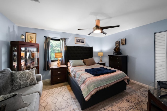 bedroom featuring light wood-style flooring, baseboards, and ceiling fan