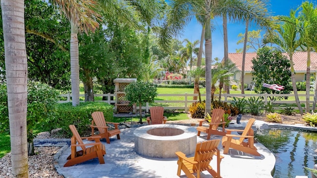 view of community with an outdoor fire pit, fence, and a patio