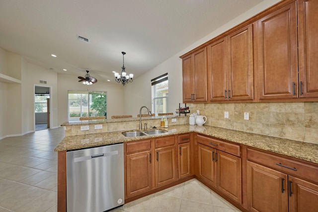 kitchen with stainless steel dishwasher, a sink, a peninsula, brown cabinets, and a chandelier