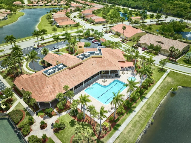 aerial perspective of suburban area featuring a pool and a large body of water