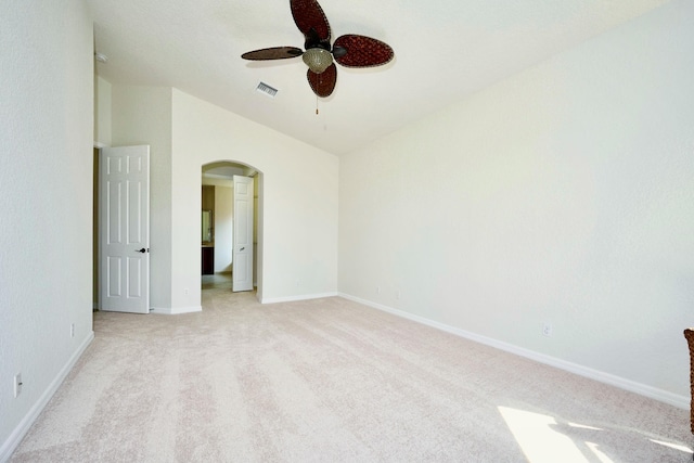 unfurnished bedroom with arched walkways, light carpet, baseboards, ceiling fan, and vaulted ceiling