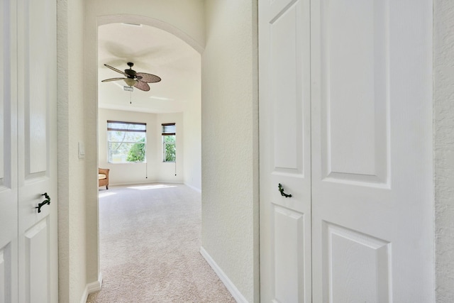 hall with carpet flooring, baseboards, and a textured wall