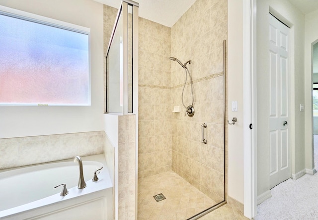 full bath with a shower stall, a garden tub, and plenty of natural light