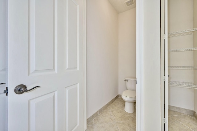 bathroom featuring tile patterned floors, baseboards, and toilet