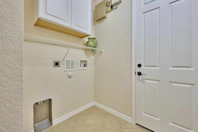 washroom featuring electric dryer hookup, cabinet space, washer hookup, light tile patterned flooring, and baseboards