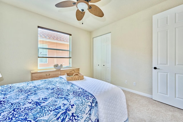 carpeted bedroom with a closet, ceiling fan, and baseboards
