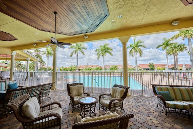 view of patio / terrace with fence, a community pool, outdoor lounge area, and ceiling fan