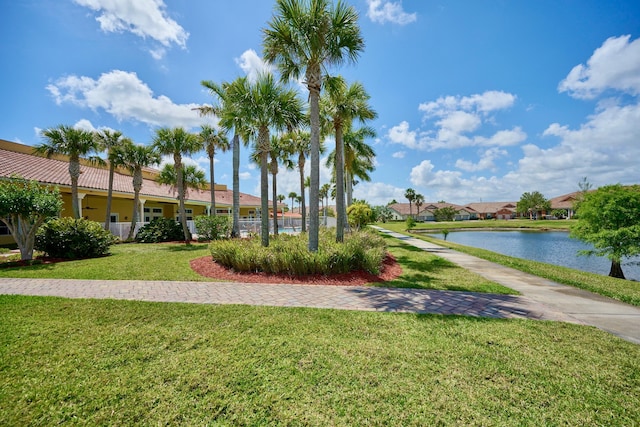 view of property's community with a lawn and a water view