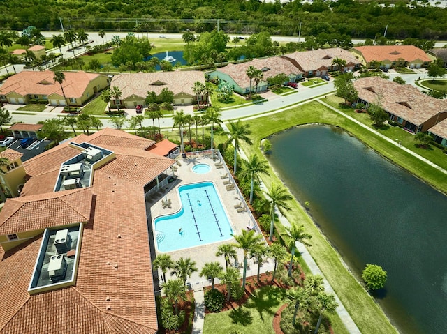 drone / aerial view of a nearby body of water and a pool area
