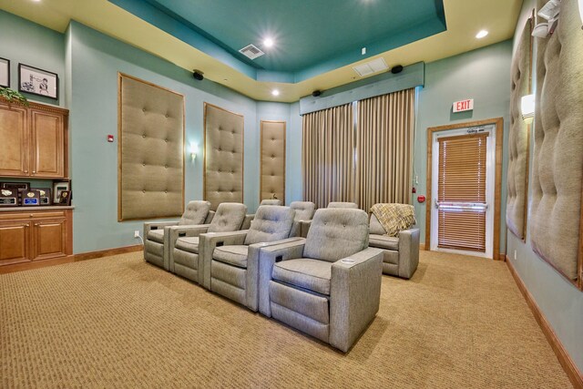 home theater room with light colored carpet, baseboards, a raised ceiling, and recessed lighting