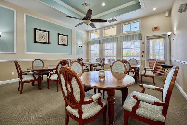 dining area featuring a tray ceiling, carpet, a ceiling fan, baseboards, and crown molding