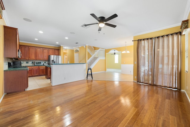 unfurnished living room with ceiling fan, crown molding, light wood finished floors, recessed lighting, and baseboards