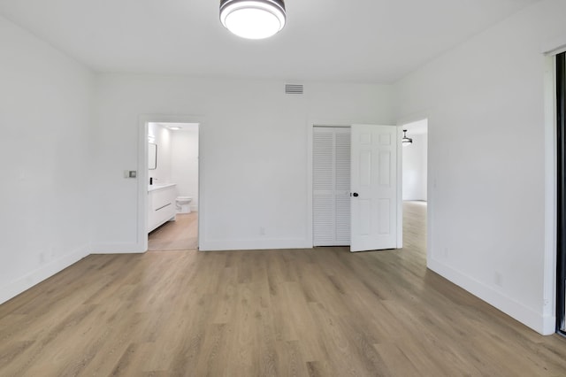 7884 Seville Pl Unit 1301, Boca Raton, FL 33433 - unfurnished bedroom featuring light wood-type flooring, baseboards, a closet, and connected bathroom