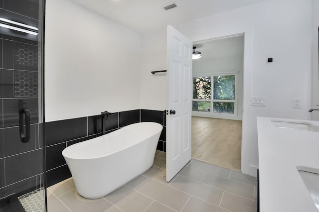 7884 Seville Pl Unit 1301, Boca Raton, FL 33433 - bathroom featuring a soaking tub, a shower stall, tile walls, vanity, and tile patterned floors