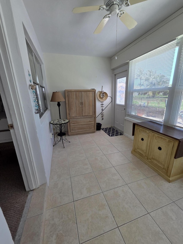 interior space featuring light tile patterned floors and ceiling fan
