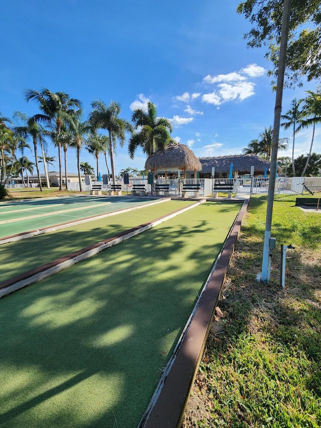 view of property's community featuring a bocce ball area, fence, and a gazebo