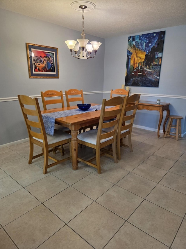 dining area featuring a chandelier, light tile patterned flooring, baseboards, and a textured ceiling