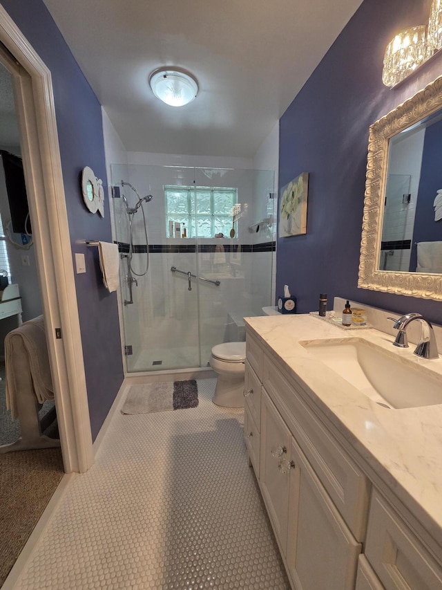 bathroom with a stall shower, toilet, and vanity