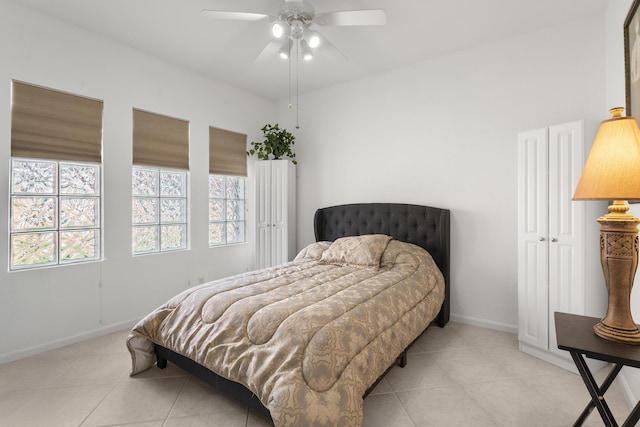 bedroom featuring light tile patterned flooring, baseboards, and ceiling fan